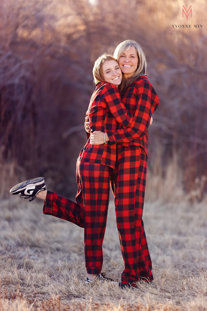 A mom and daughter pose in red matching pajamas in Thornton, Colorado during family photos with Yvonne Min.