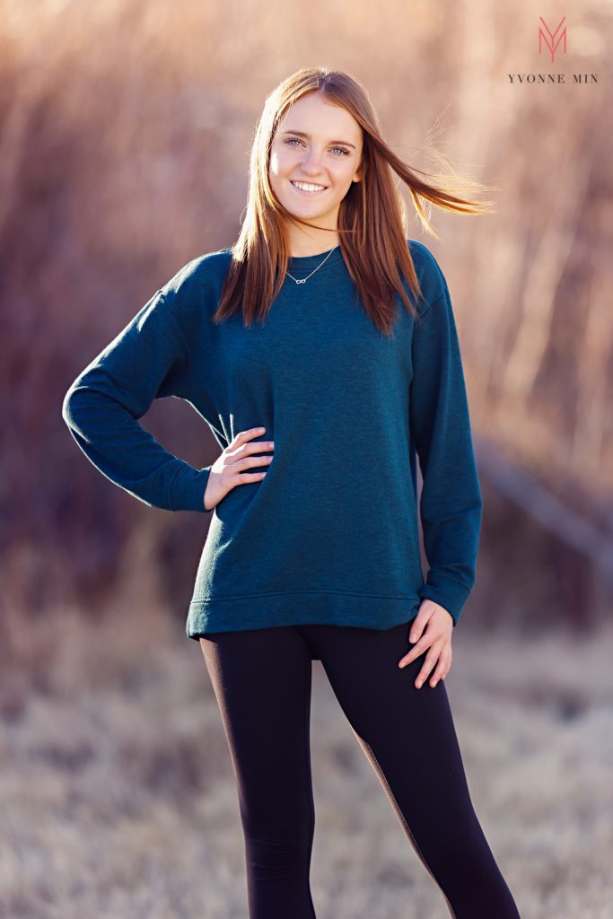 A teen girl poses with her hand on her hip during her family photoshoot with Yvonne Min in Thornton, Colorado.