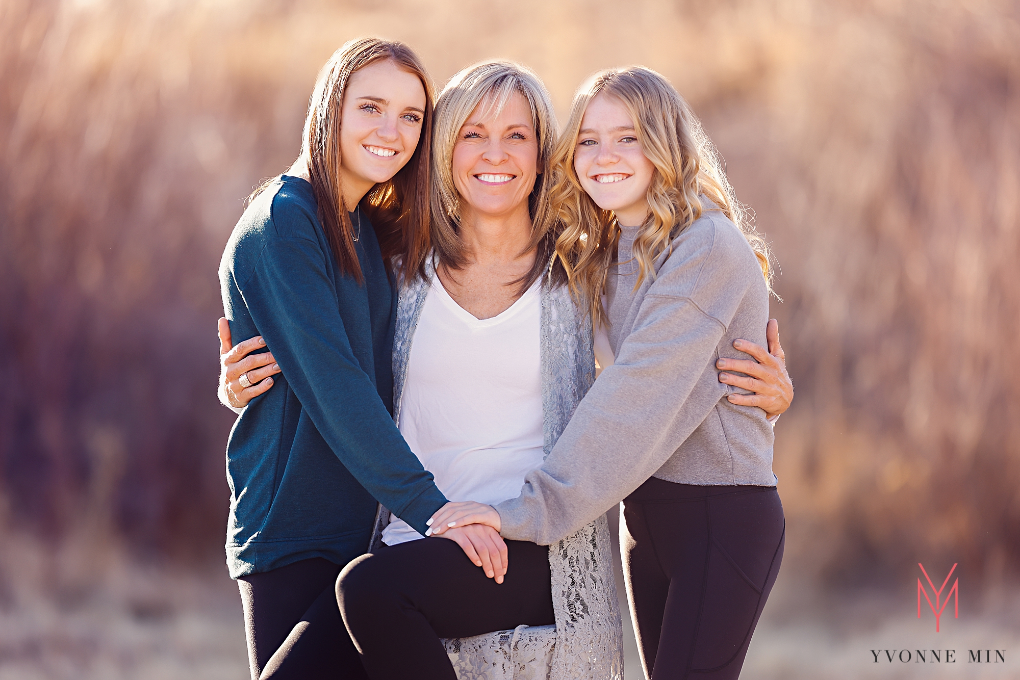 Mother and her two daughters pose for a family photograph.