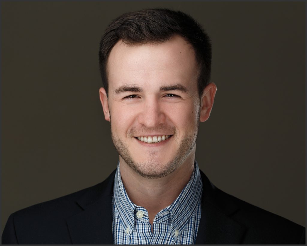 A headshot on a dark gray background for a new hire at a Denver, Colorado recycling corporation.