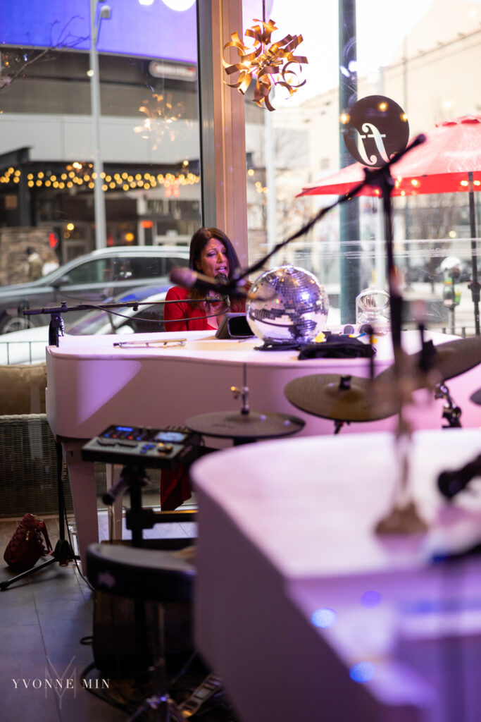 A female piano player sings to an audience at Fortissimo Dueling Pianos in downtown Denver, Colorado.