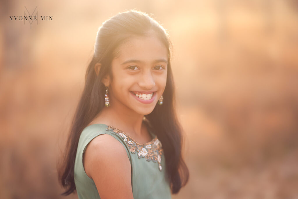 A young Indian girl smiles at the camera during his family photography session.