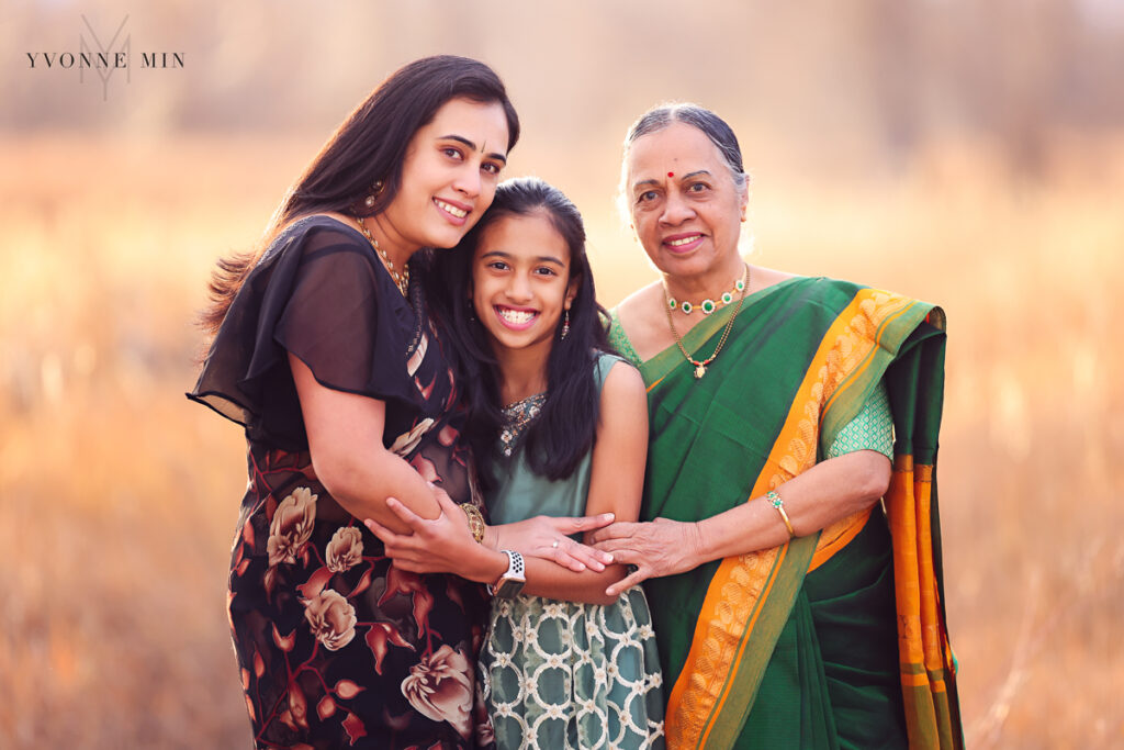 A mother, grandmother and daughter hug together in traditional Indian sarees at East Lake in Thornton, Colorado.