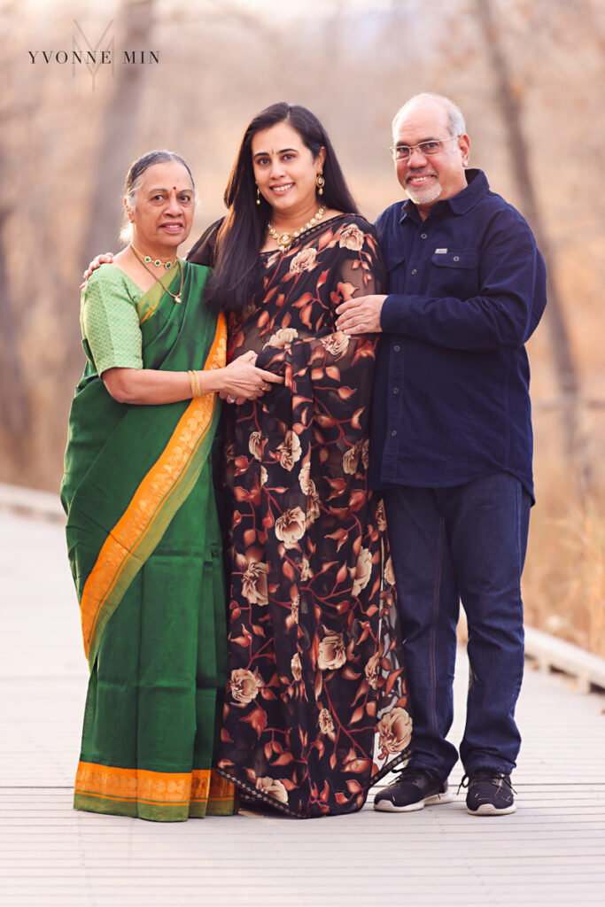 Parents pose with their daughters in traditional sarees at a family shoot in East Lake, Thornton, Colorado.