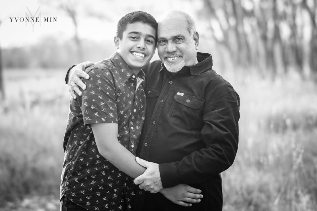 A grandfather hugs his grandson at a family photoshoot with Yvonne Min Photography at East Lake in Thornton, Colorado.