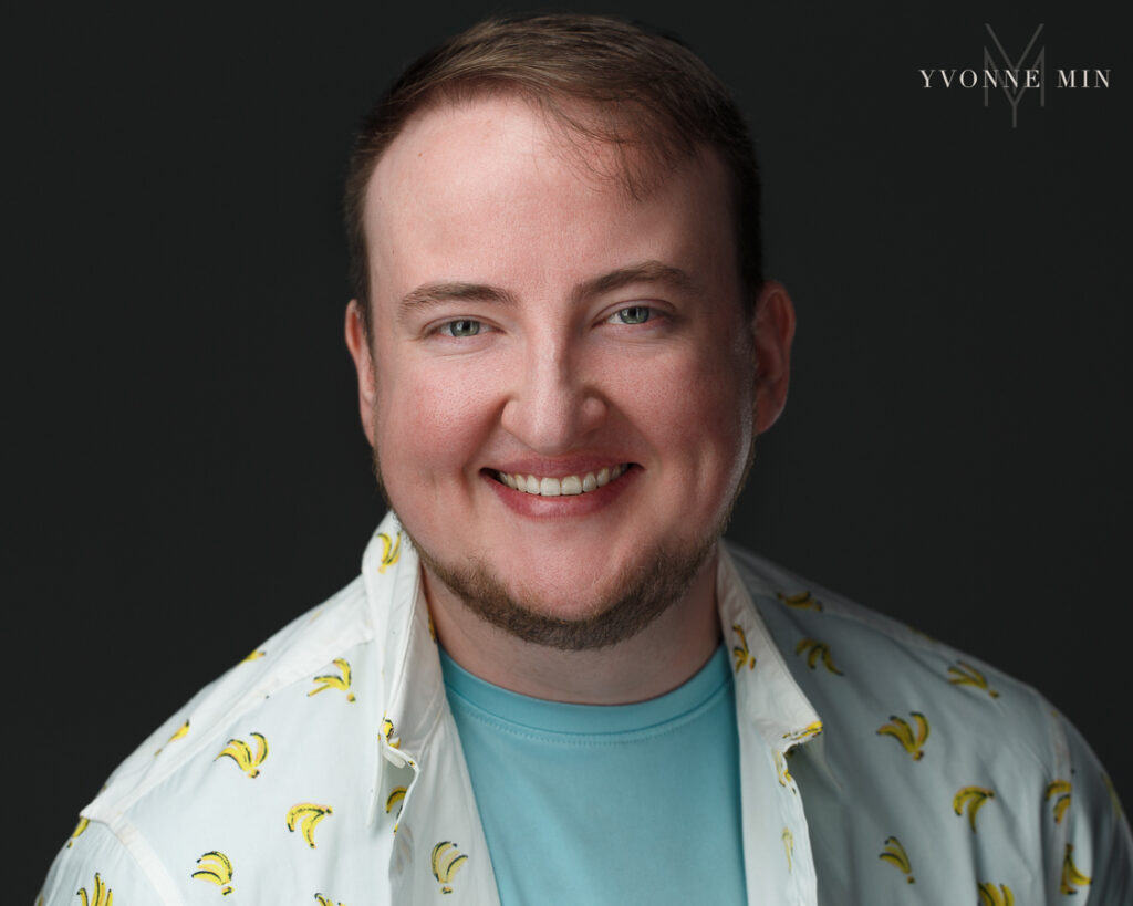 A headshot photo of an actor with a shirt with bananas on a dark ground taken by Yvonne Min Photography in Thornton, Colorado.