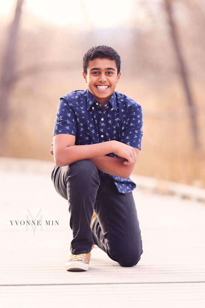 A young teenager poses on a bridge during a family photoshoot in Thornton, Colorado.