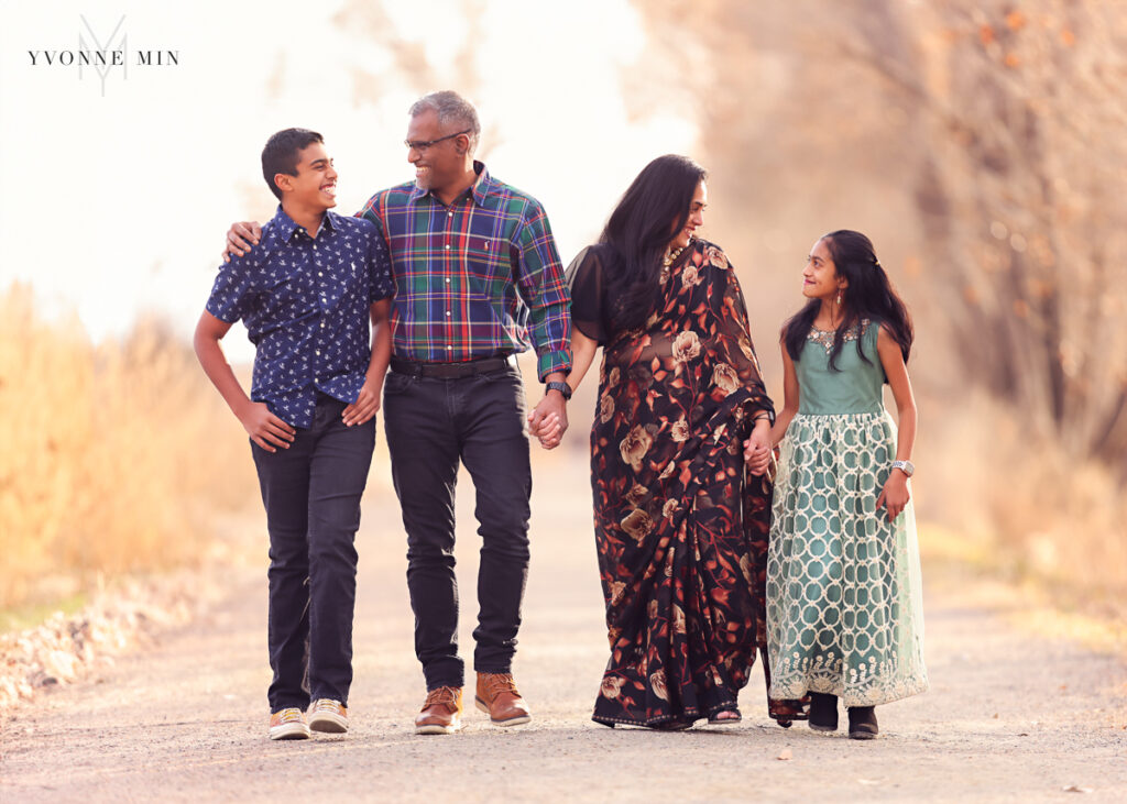 A family of four walk along East Lake in Thornton, Colorado during their family photoshoot.