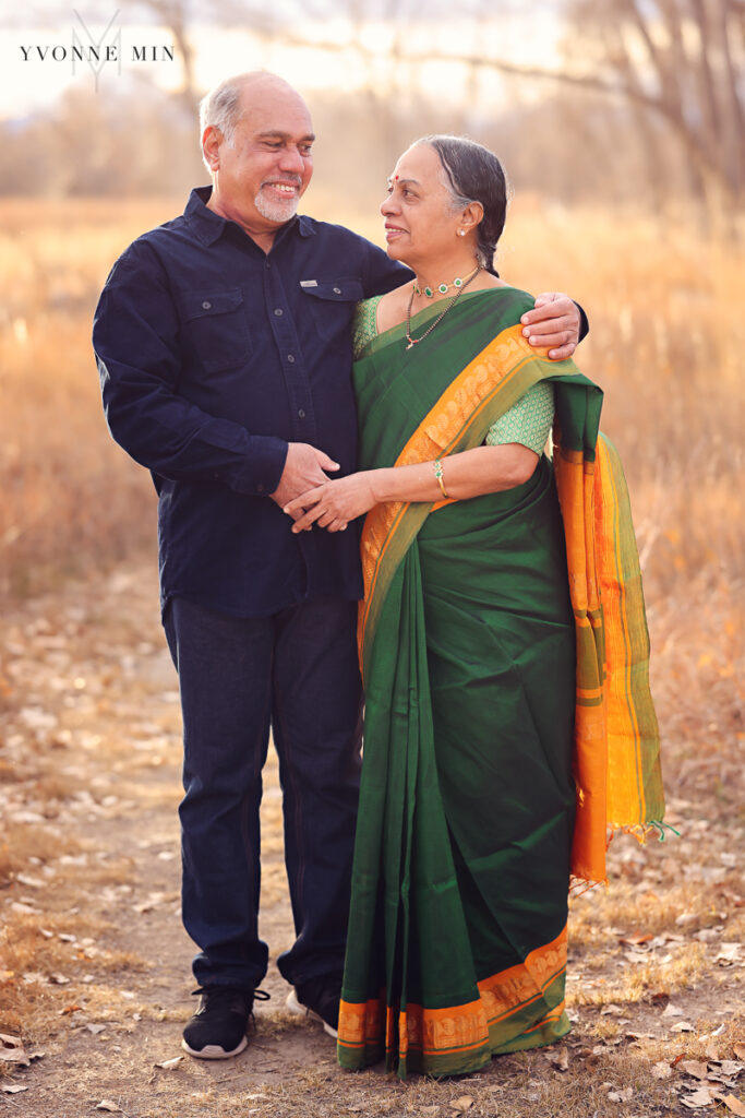 A couple looks at each other in a field at a photoshoot with Yvonne Min Photography.