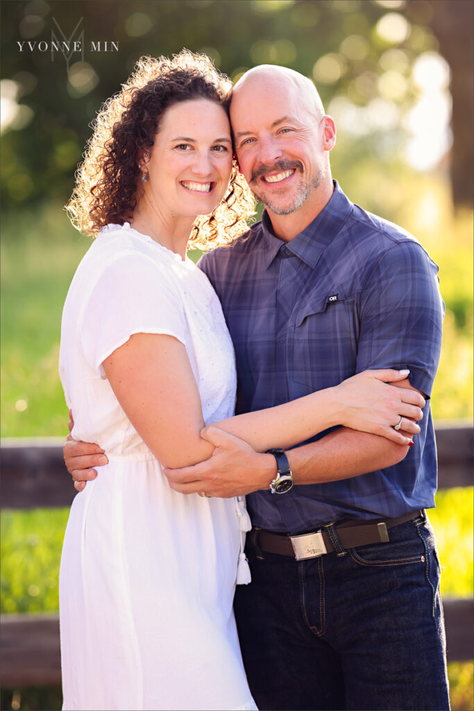 A mom and dad hug at McKay Lake during their family photoshoot with Yvonne Min Photography in Westminster, Colorado.