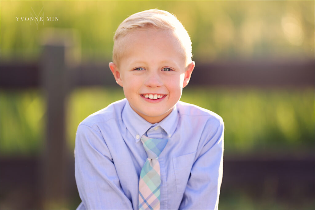 A photograph of a young boy in a tie taken at McKay Lake in Westminster, Colorado by Yvonne Min Photography.