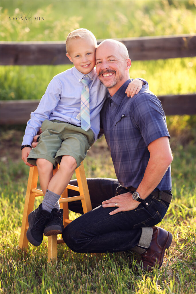 A dad and son pose at McKay Lake during their family photoshoot with Yvonne Min Photography in Westminster, Colorado.