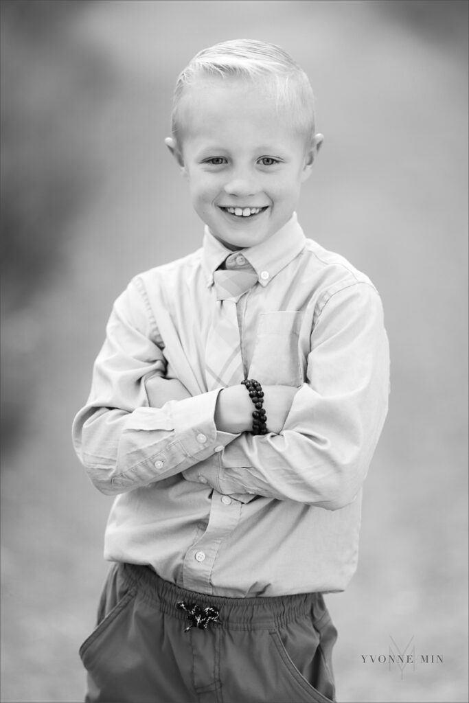 A black and white photograph of a young boy posing at McKay Lake during his family photoshoot with Yvonne Min Photography in Westminster, Colorado.