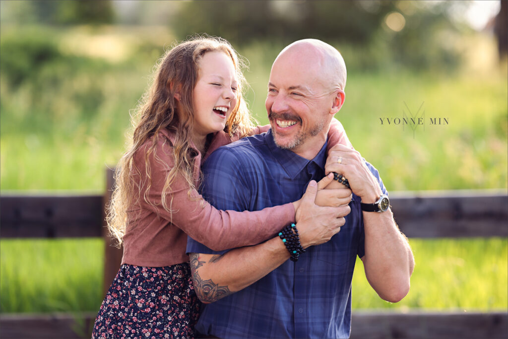 A photograph of a dad and daughter laughing during their family photoshoot with Yvonne Min Photography in Westminster, Colorado.