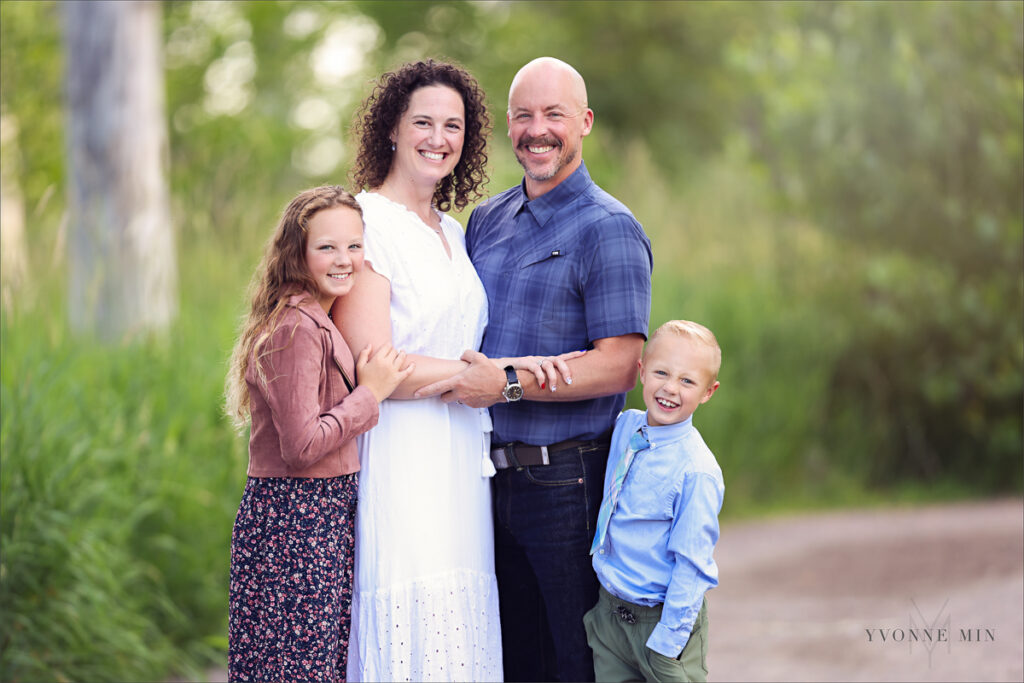 A photograph of a family of four posing at their family photoshoot with Yvonne Min Photography in Westminster, Colorado.