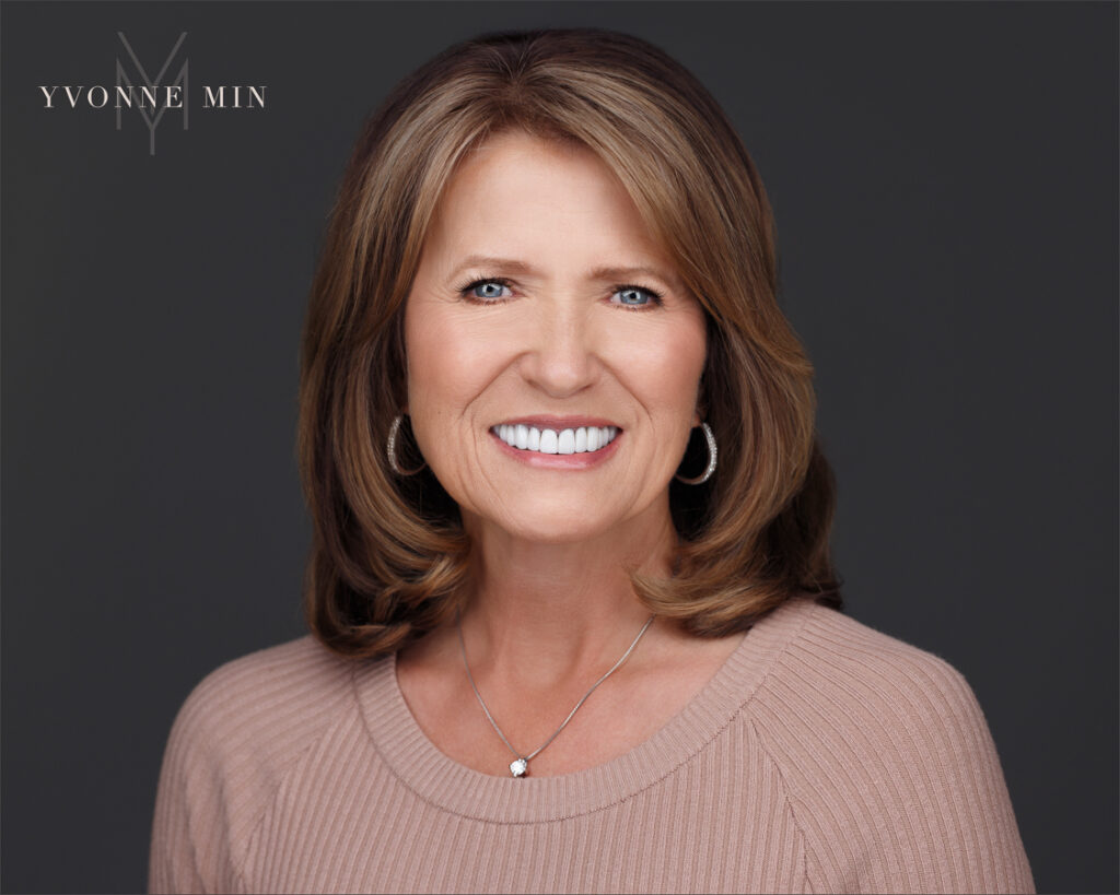 A headshot of a woman in a leadership position taken on a dark gray background by Yvonne Min Photography.