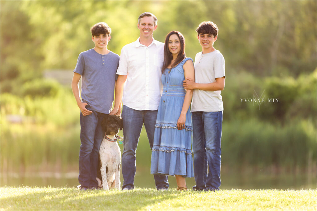 A family photograph taken with their dog in front of a lake in Purple Park, Superior, Colorado by Yvonne Min Photography.