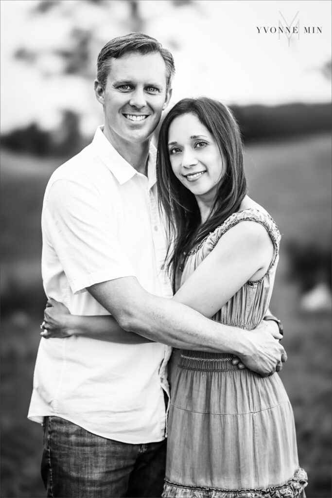 A mom and dad embrace each other in a black and white portrait at their family photography session with Yvonne Min Photography in Superior, Colorado.