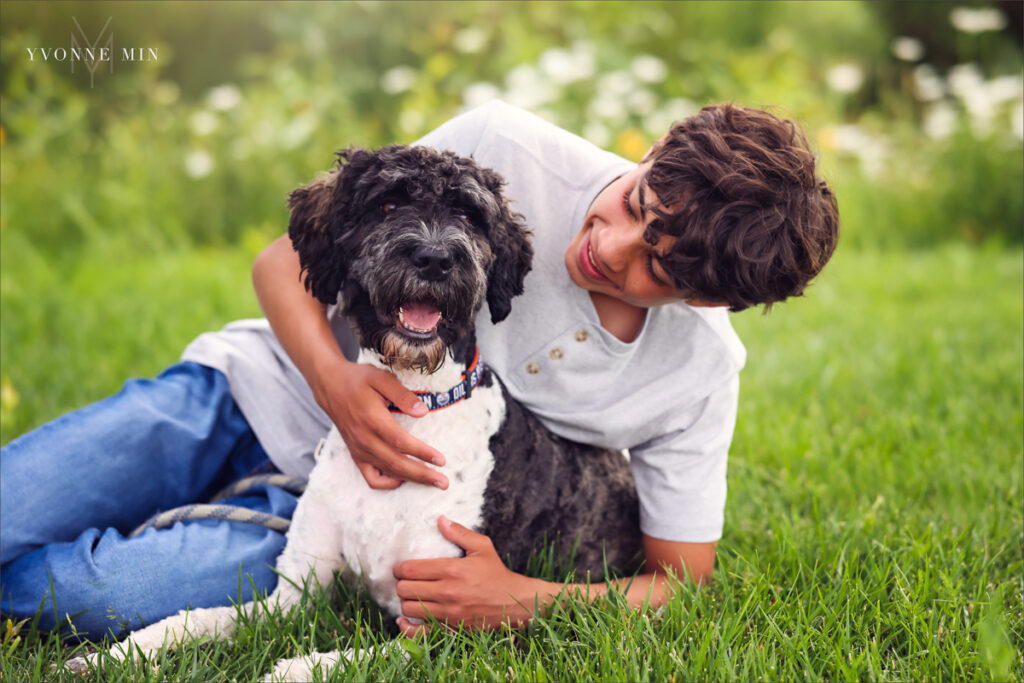 A close-up portrait of a teenage boy petting his dog taken in Purple Park, Superior, Colorado by Yvonne Min Photography.