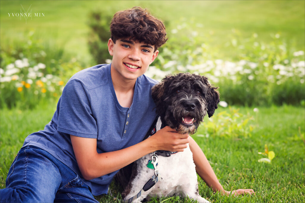 A close-up portrait of a teenage boy petting his dog taken in Purple Park, Superior, Colorado by Yvonne Min Photography.