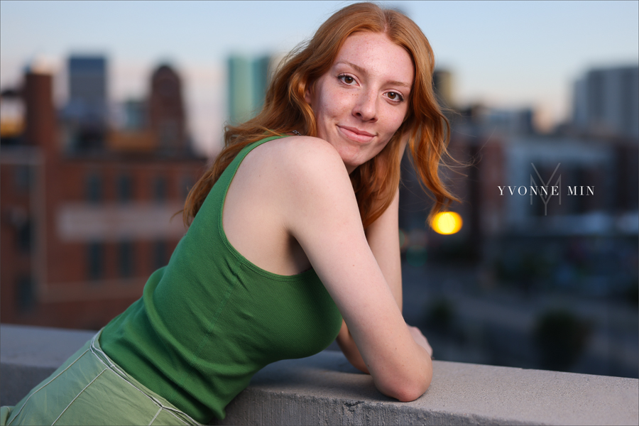 A high school senior girl poses on top of a rooftop in the RiNo Art District of Denver with Yvonne Min Photography.