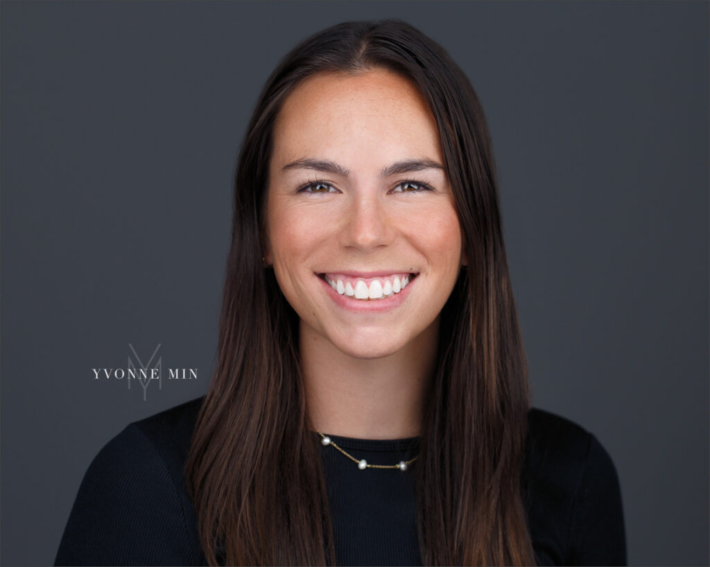 A headshot of a young woman in black shirt taken with a white background at Yvonne Min Photography in Thornton, Colorado.