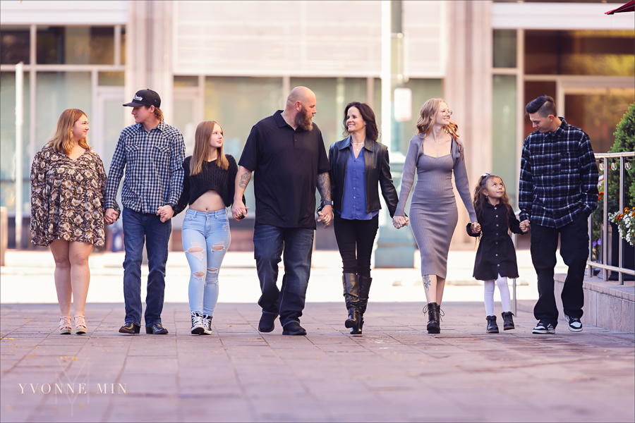 A family photograph with eight people walking together taken outside Union Station in downtown Denver by Yvonne Min Photography.