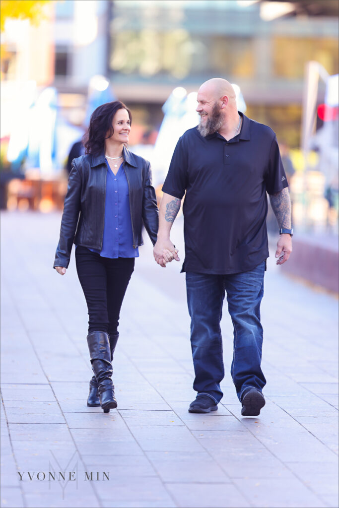 A mom and dad walking together taken outside of Union Station in downtown Denver by Yvonne Min Photography.