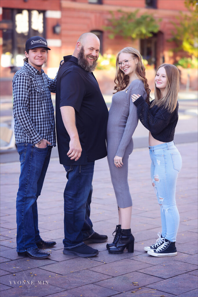 An exepecting mom and her dad have their bellies touch at a family photography session in LoDo Denver taken by Yvonne Min Photography.