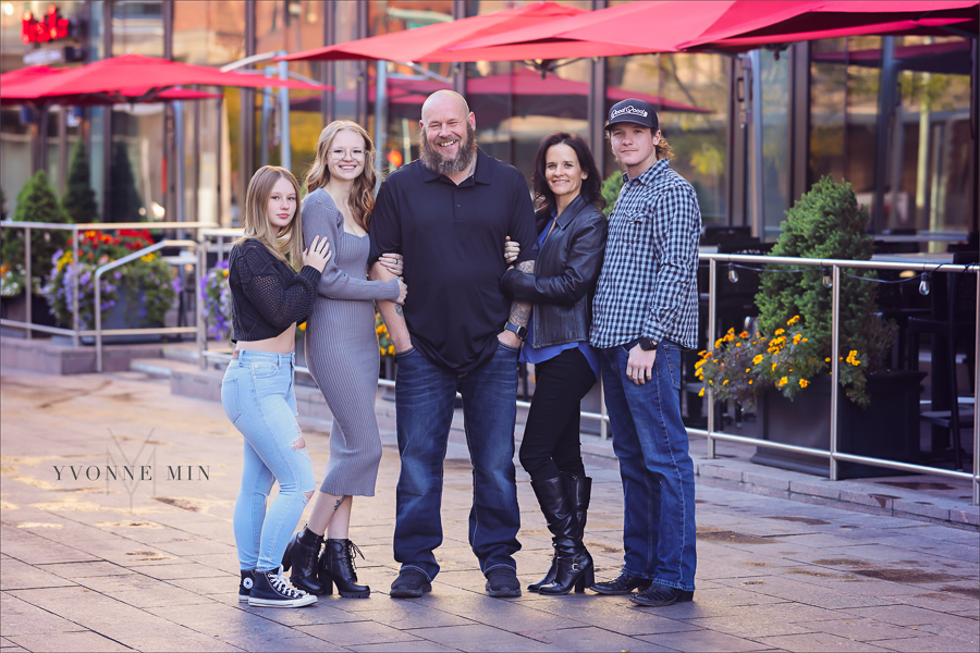 A family hugs each other outside Union Station in LoDo Denver during a family photography session with Yvonne Min Photography.