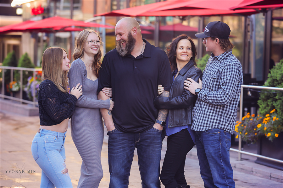 A family laughs together outside Union Station in LoDo Denver during a family photography session with Yvonne Min Photography.