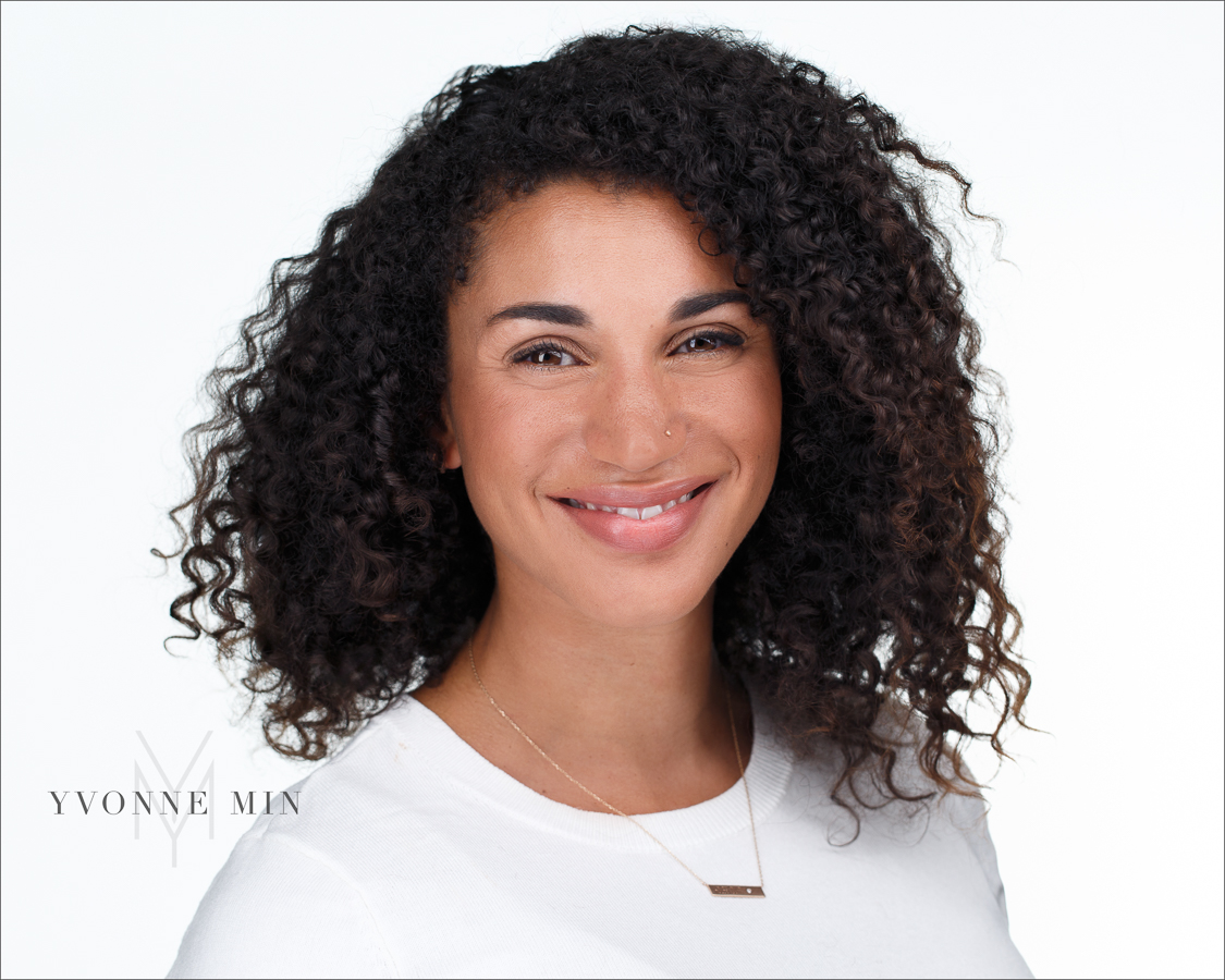 A headshot of a young woman on a white backdrop photographed by Yvonne Min in Thornton, Colorado.