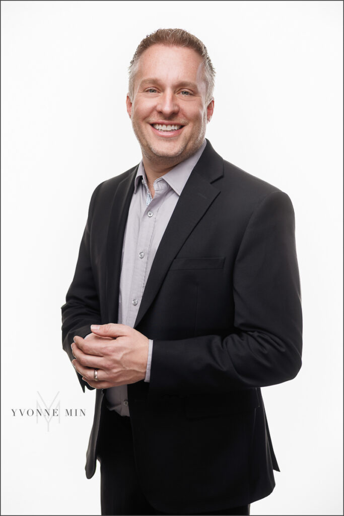 A new headshot for a man running for Thornton City Council photographed by Yvonne Min Photography on a white backdrop at her studio in Thornton, Colorado.