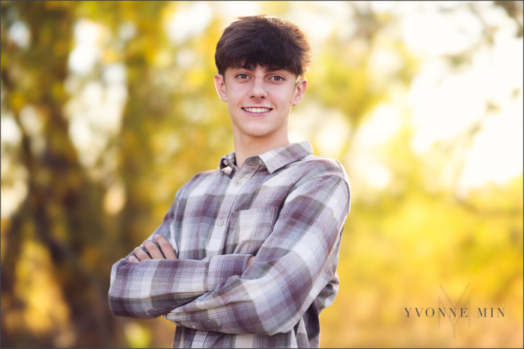 A young man poses with his arms crossed at his family photography session with Yvonne Min Photography in Thornton, Colorado.