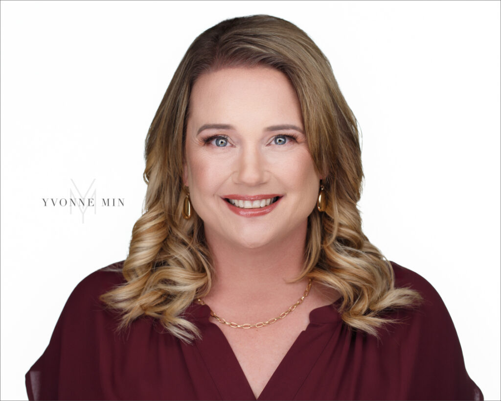 A new professional headshot for a real estate agent photographed on a white backdrop in the studio of Yvonne Min Photography in Thornton Colorado.