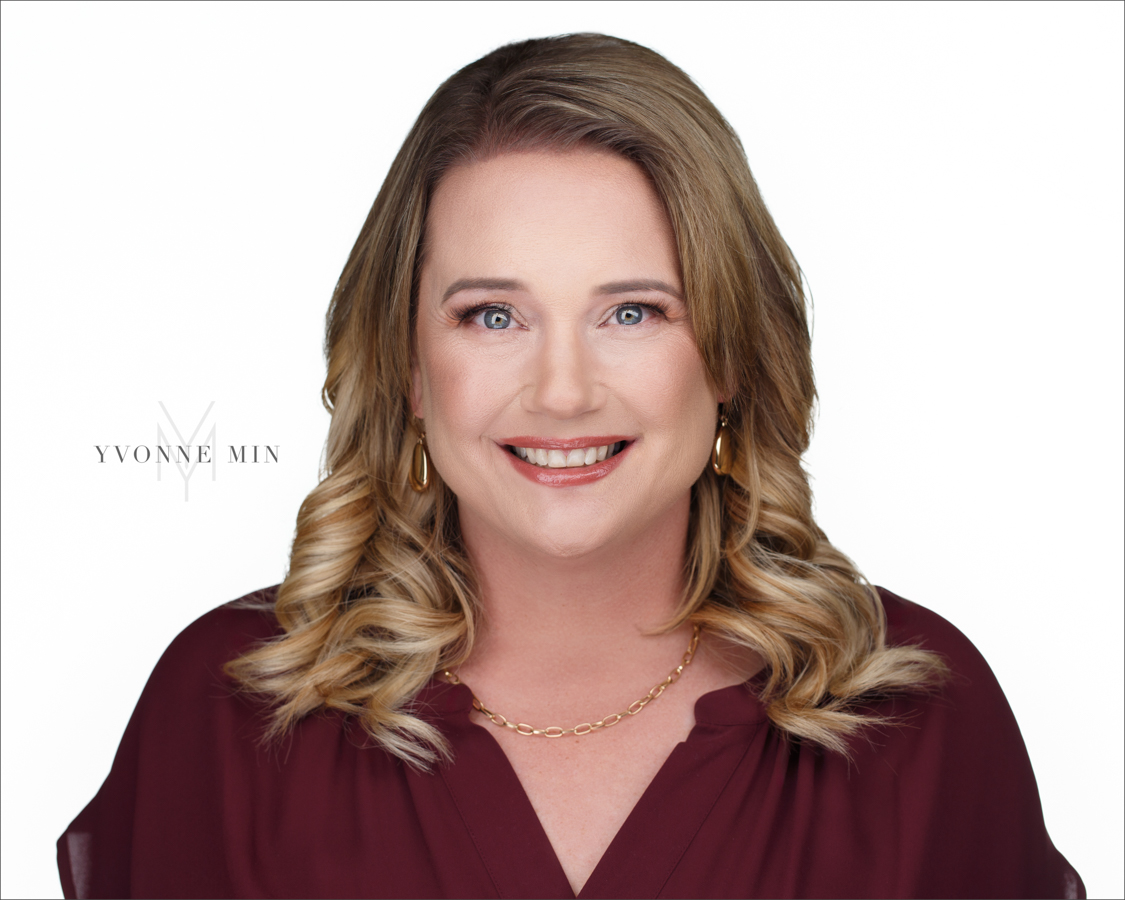 A new professional headshot for a real estate agent photographed on a white backdrop in the studio of Yvonne Min Photography in Thornton Colorado.