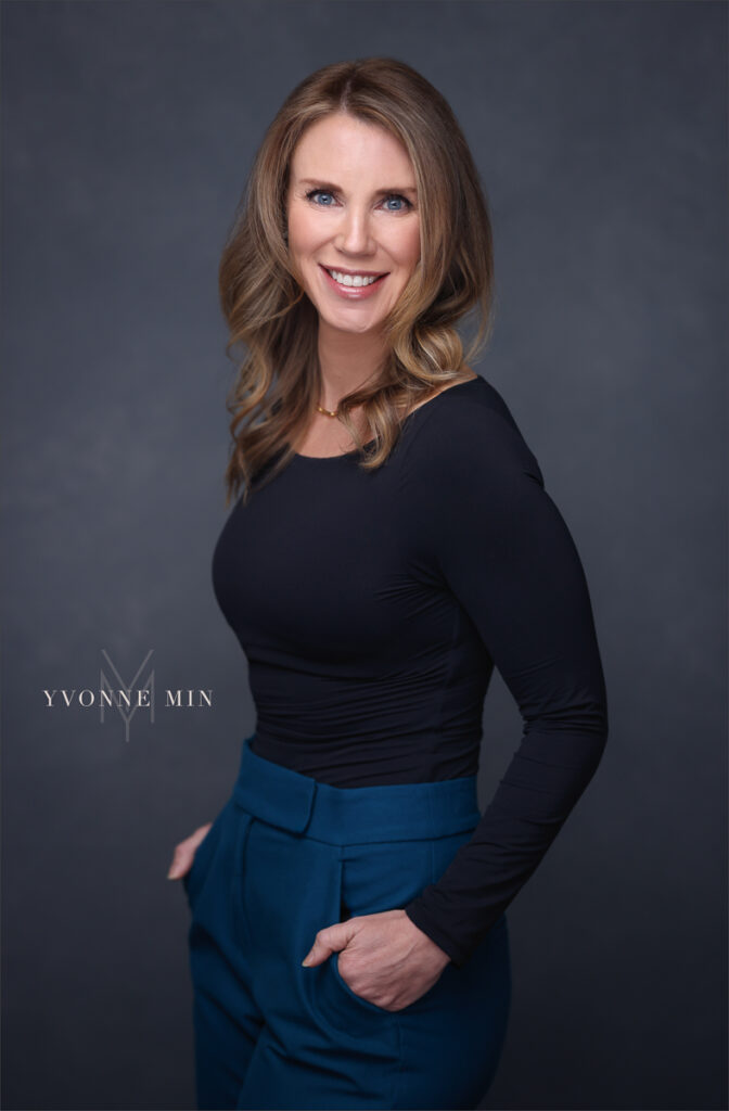 A professional new photograph for a business woman on a gray backdrop at the studio of Yvonne Min Photography in Thornton, Colorado.