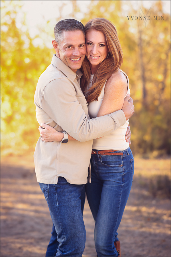 A family photograph of a mom and dad hugging each other with Yvonne Min Photography in Thornton, Colorado.