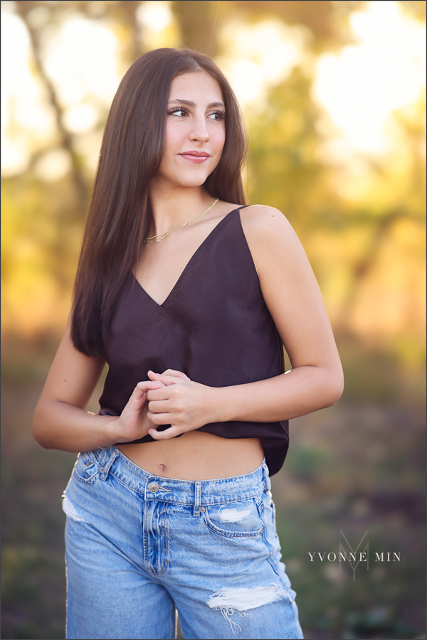 A photograph of a younger teen girl looking off Into the distance at her family photography session with Yvonne Min Photography in Thornton, Colorado.