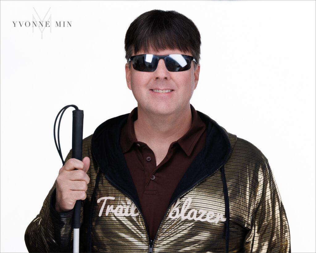 A headshot of the founder of the Blind Institute of Technology taken at the Yvonne Min Photography Studio in Thornton, Colorado on a white backdrop.
