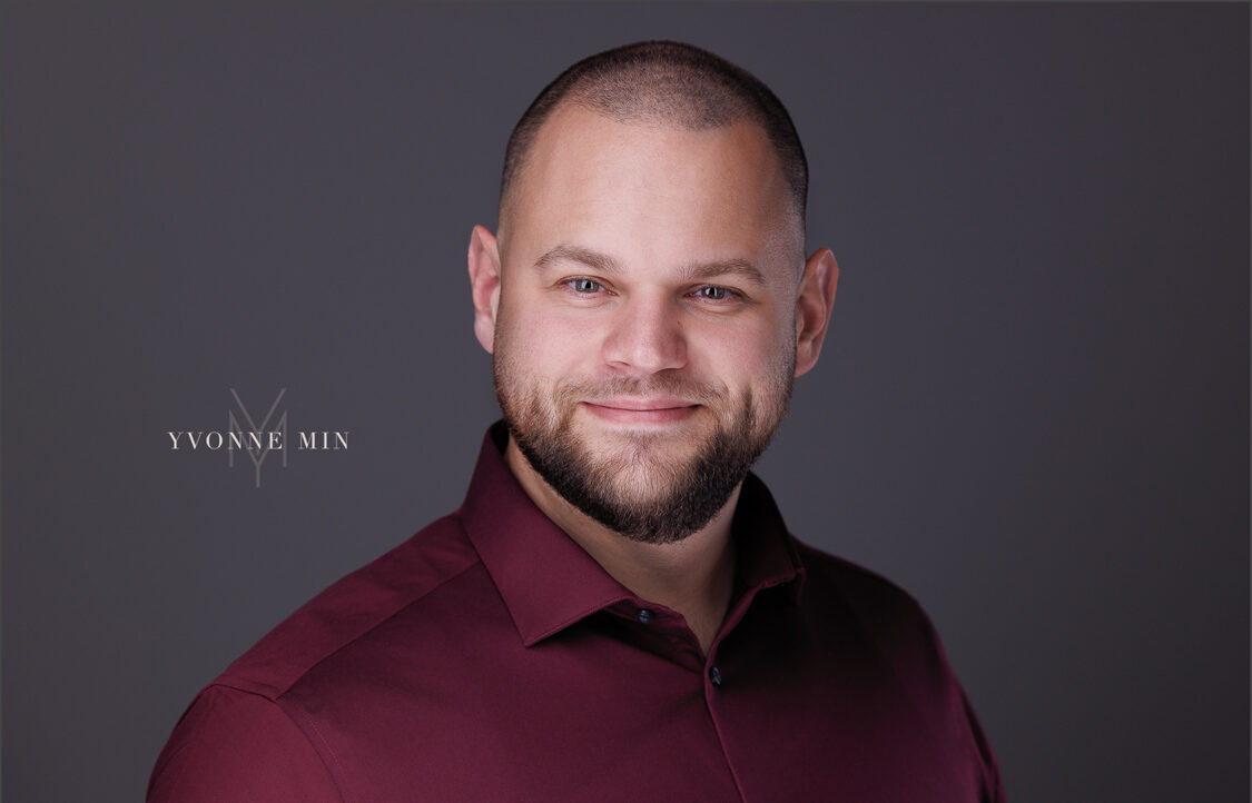 A new headshot for a business professional photographed on a dark gray background in the studio of Yvonne Min Photography in Thornton, Colorado.